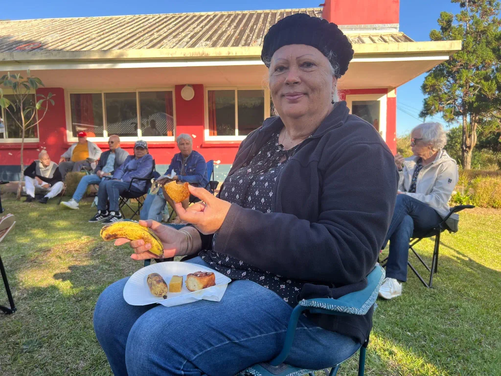 Senior dégustant une collation (banane, gâteau) lors de la pause