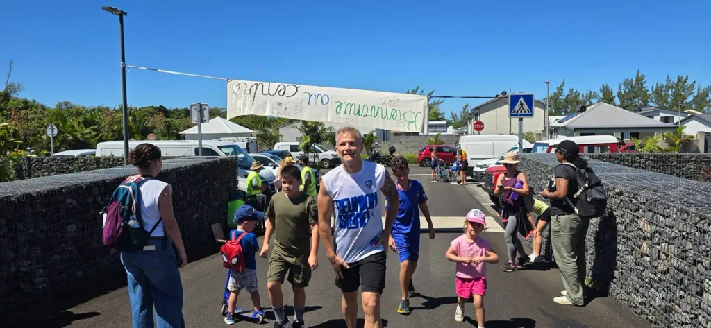 le maire souriant entouré d'enfants sur la route