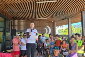 Organisatrice s'exprimant au micro devant les participants et le public