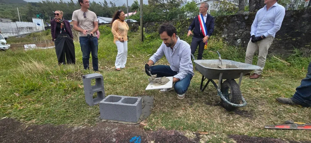 Un partenaire applique du mortier sur un parpaing
