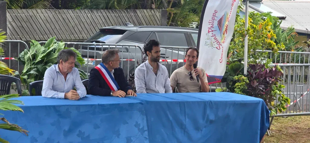 le maire et des partenaires assis à la tribune, micro en main 