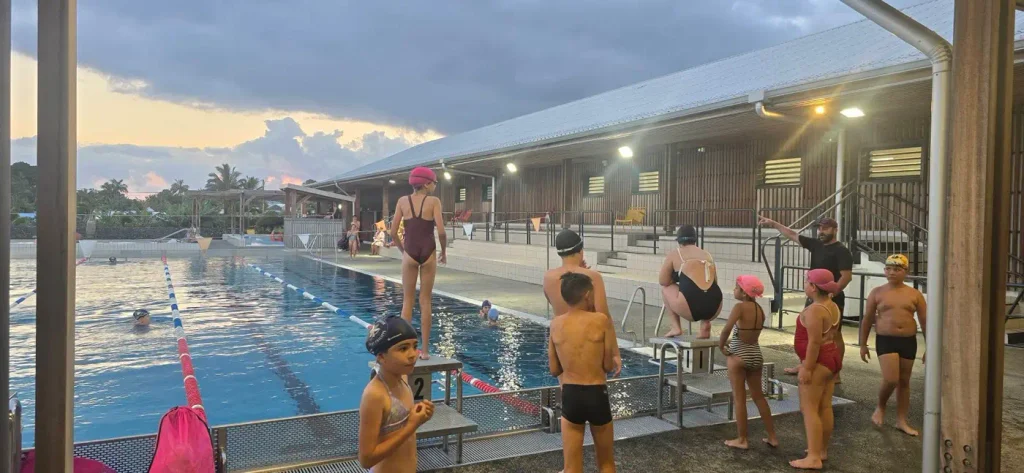 Enfants en bonnet de bain debout au bord du bassin