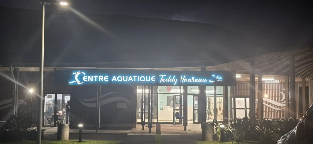 Entrée du Centre Aquatique Teddy Hoareau et son enseigne lumineuse