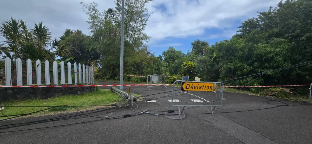 Panneau « Déviation » devant des câbles et un poteau couchés sur la route