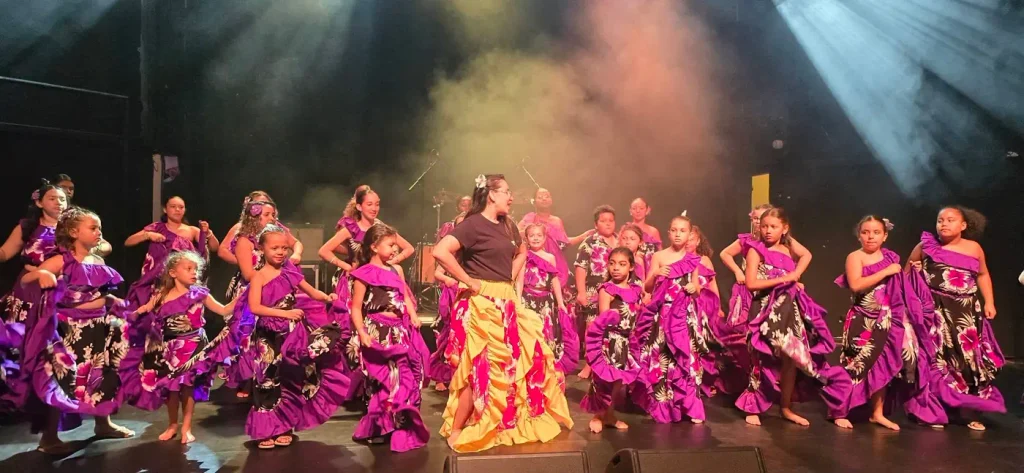 Danseuses font tourner leurs jupes violettes sous des projecteurs colorés