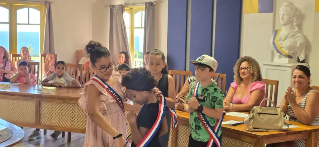 la mairesse enfant remet leur écharpe à ses adjoints