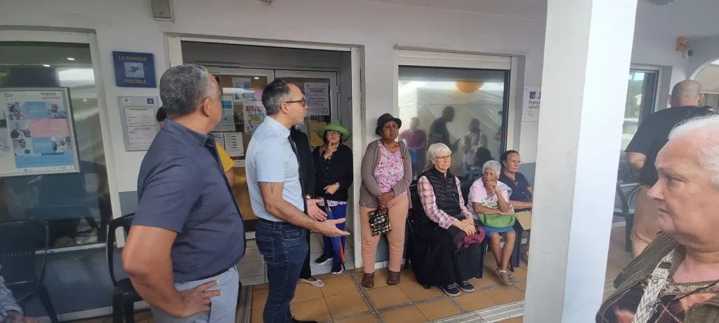 Les organisateurs s'adressant aux habitants assis devant La Poste