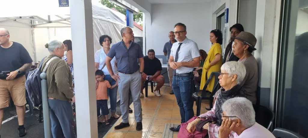 Organisateurs dialoguant avec des habitants assis sous l'auvent de La Poste