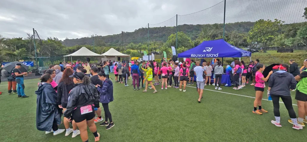 Foule de participantes en rose rassemblées sur le terrain de sport