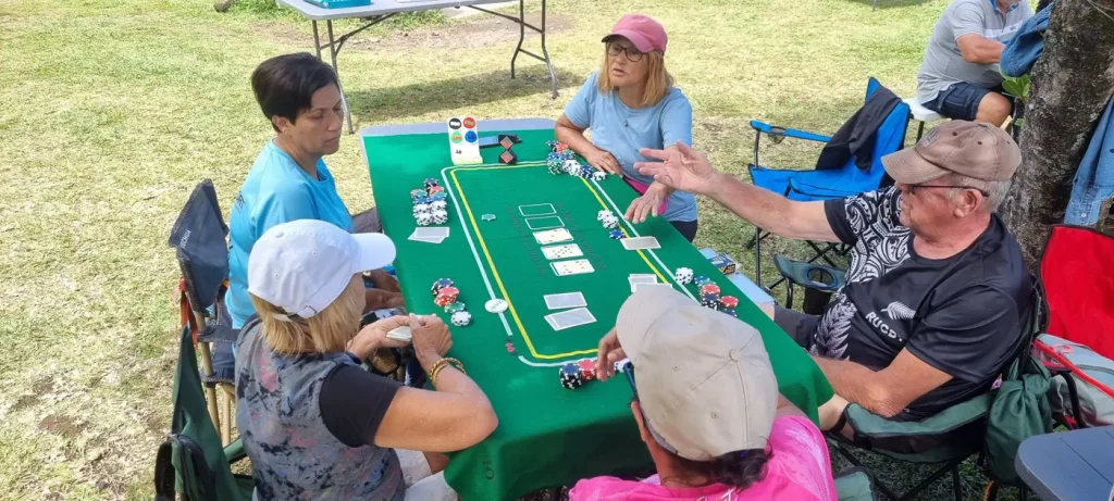 Groupe de seniors jouant aux cartes autour d'une table de jeu verte