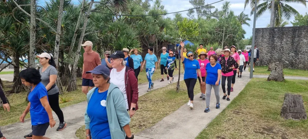 Groupe de seniors marchant sur un chemin bordé de vacoas