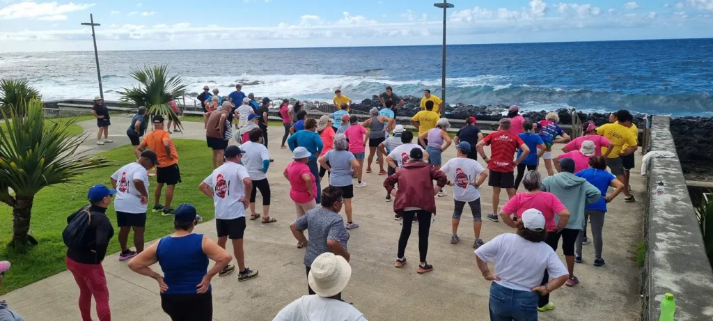 Séance de gym en plein air face à l'océan, participants en mouvement
