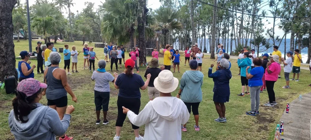 Participants réunis en cercle sur la pelouse pour un exercice collectif