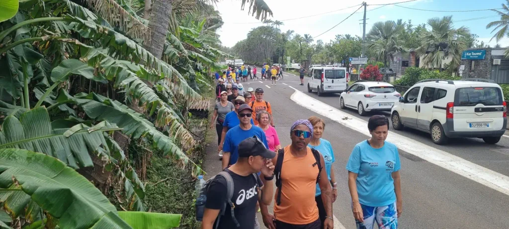 Marcheurs en tee-shirts colorés le long d'une route bordée de bananiers