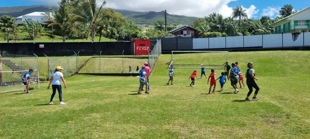 Enfants et seniors jouent ensemble au football sur la pelouse