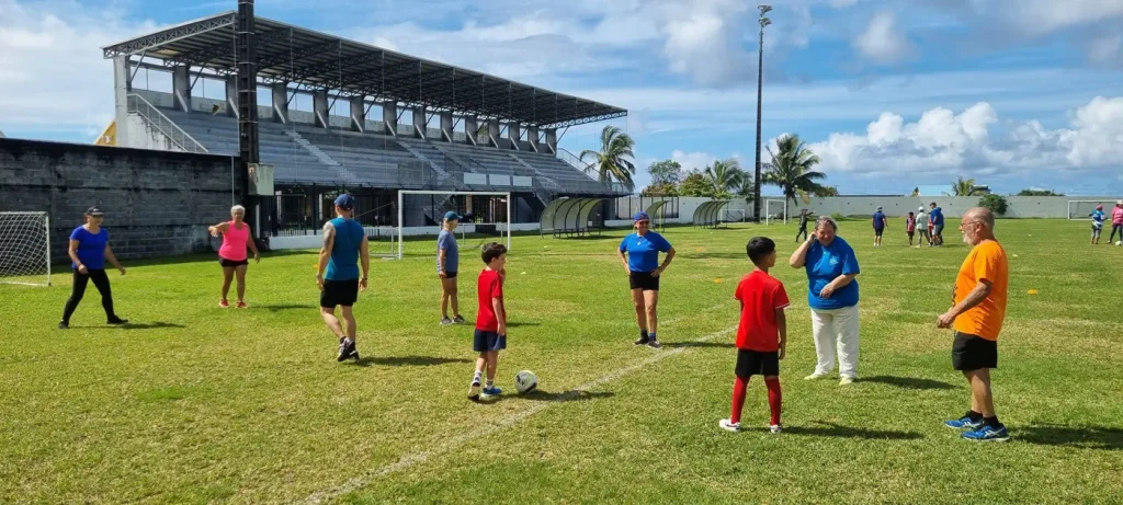 Match de football mixte entre enfants et seniors sur le terrain